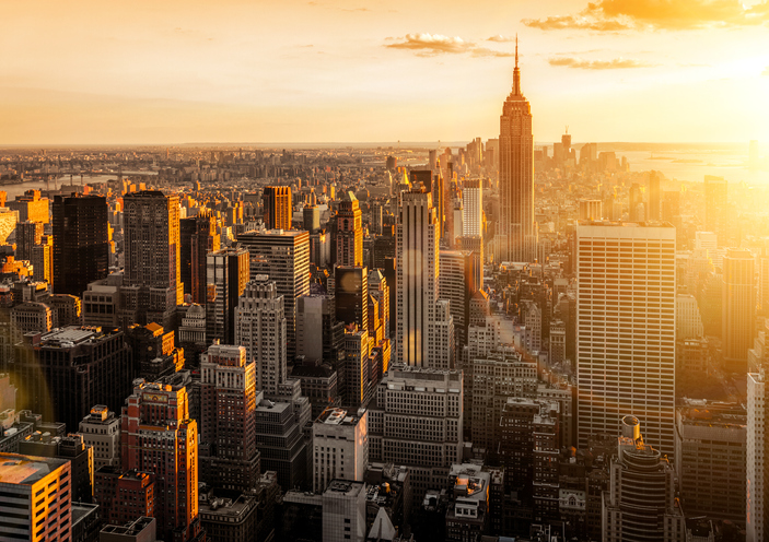 The New York City skyline of commercial buildings at sunset.